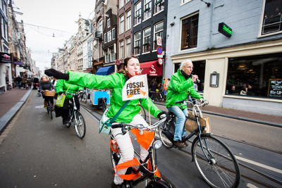 Activists ride bikes through the streets of Amsterdam on Global Divestment Day. Credit: Nichon Glerum www.nichon.nl